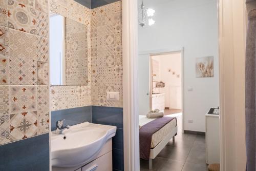 a bathroom with a sink and a bed and a mirror at Casa Vacanze Lu Rizzaru in Nardò