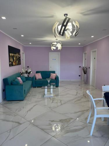 a living room with a blue couch and a chandelier at Mare Azzurro in Marina di Camerota