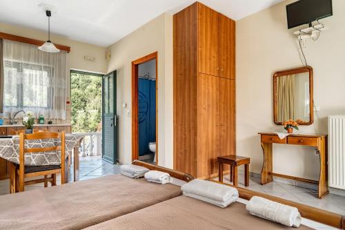 a bedroom with a bed and a table and a mirror at Daratos studio 1 in Kefallonia