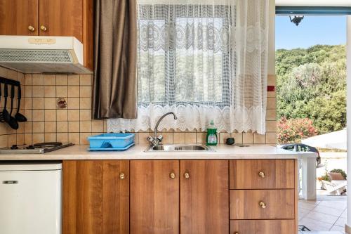 a kitchen with a sink and a window at Daratos studio 1 in Kefallonia