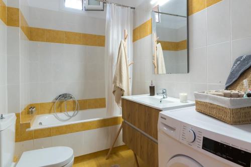 a bathroom with a sink and a washing machine at Joan Serenity Apartment in Porto Heli