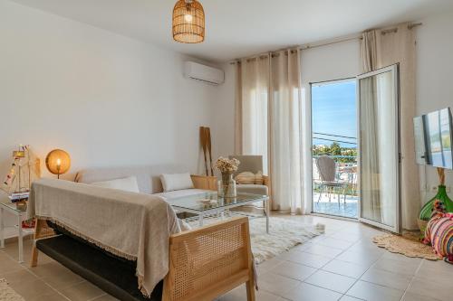 a living room with a couch and a table at Joan Serenity Apartment in Porto Heli