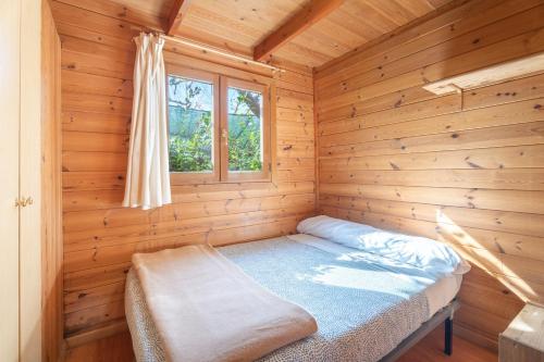 a small room with a bed in a wooden cabin at Falaguera Cabaña 2 in Bárig
