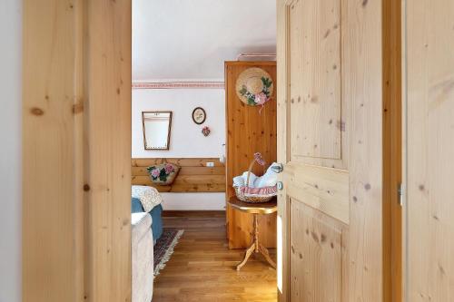 a hallway with wooden walls and a room with a table at Casa Zarina Well-kept Two-room in Cavalese