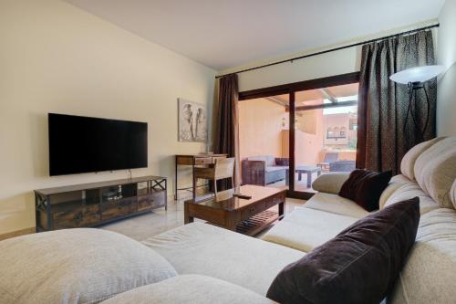 a living room with two couches and a flat screen tv at Superb 2-bed apartment in Duquesa in Manilva