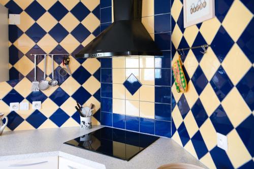 a kitchen with a blue and white tiled wall at Le Clos Rilda en Bounet in Villefranche-de-Lauragais