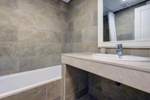 a bathroom with a sink and a bath tub at Superb 2-bed apartment in Duquesa in Manilva
