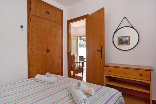 a bedroom with a bed and a dresser and a mirror at Casa Antonia 2 in Conil de la Frontera