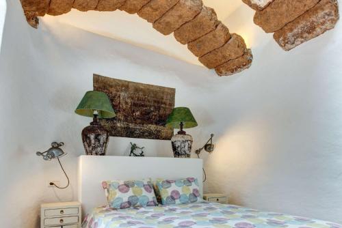 a bedroom with a bed and two lamps on the wall at Villa La Cueva in Teguise