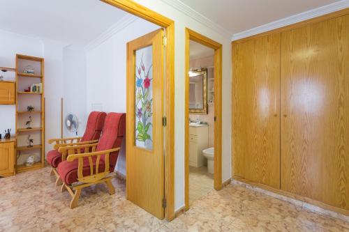 a living room with a chair and a bathroom at Bonanza in Gandía