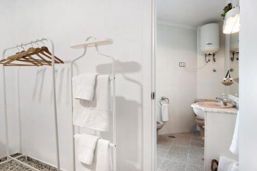 a white bathroom with a shower and a sink at Casa Rincón del Beso in Vejer de la Frontera