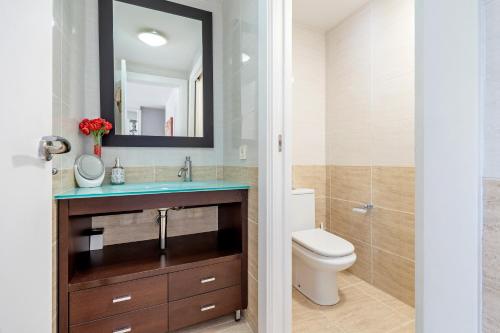 a bathroom with a toilet and a sink and a mirror at Casa Roc De Sant Gaietà in Roda de Bará