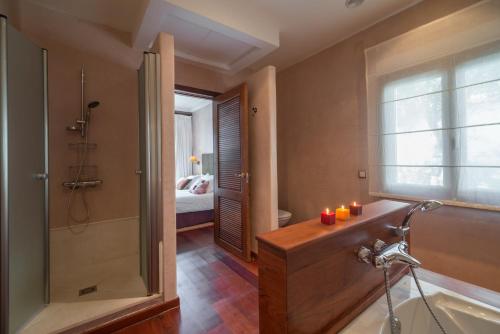 a bathroom with a tub and a shower with candles at Villa Lavanda in Benalup Casas Viejas