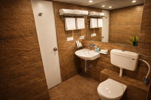 a bathroom with a toilet and a sink and a mirror at The Weekend Address Managed By Stayzy in Dumas