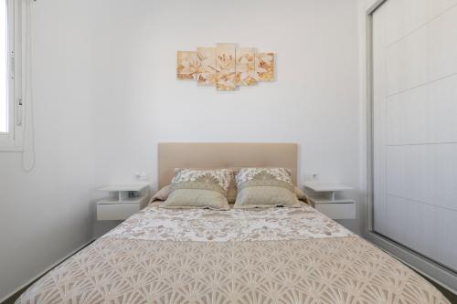 a white bedroom with a bed with two pillows at El Descanso in Conil de la Frontera