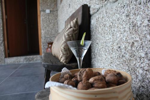 a bowl of nuts in a basket with a glass at Casa do Sobreira in Vieira do Minho