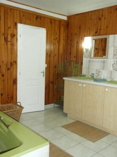 a kitchen with wooden walls and a white door at Suite familiale - Gîte du Moulin in La Noue