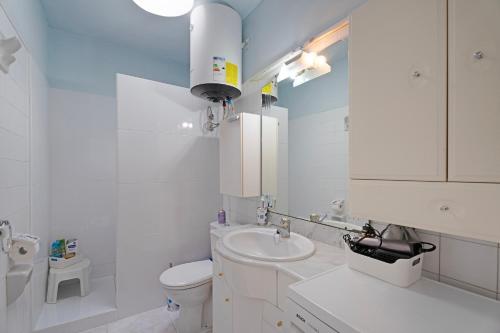 a white bathroom with a toilet and a sink at Casa Noa in Costa Del Silencio