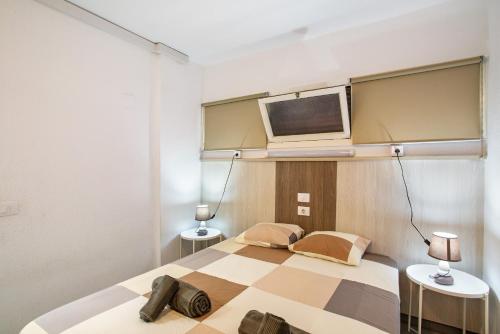 a bedroom with a bed and a tv on a wall at Beautiful Apartment 1115 Central in San Bartolomé