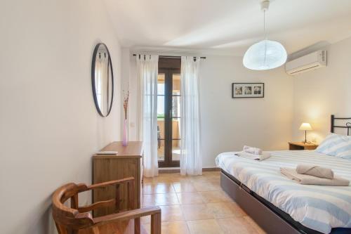 a bedroom with a bed and a desk and a chair at Los Albatros in Ayamonte