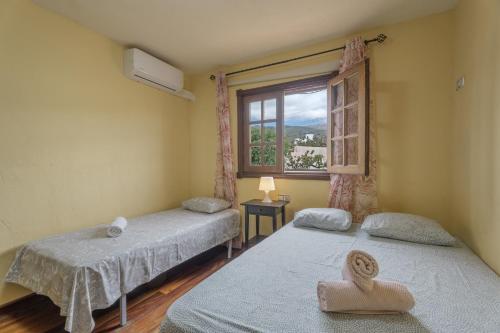 two twin beds in a room with a window at Casa El Pinito No Groups Under 27 in Tamaide