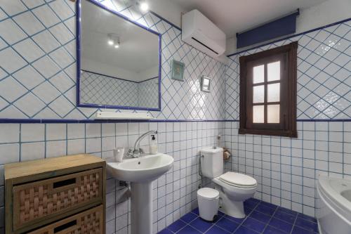 a blue tiled bathroom with a toilet and a sink at Casa El Pinito No Groups Under 27 in Tamaide