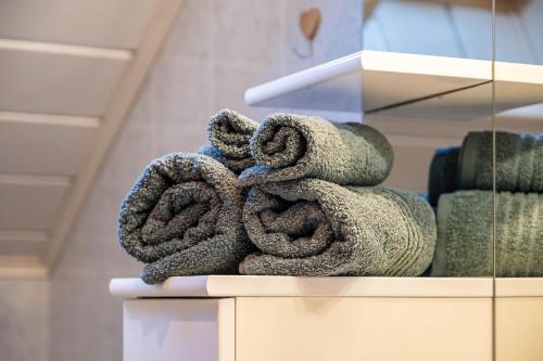 a pile of towels sitting on top of a shelf at Weingartnerhof Calendula in San Genesio Atesino