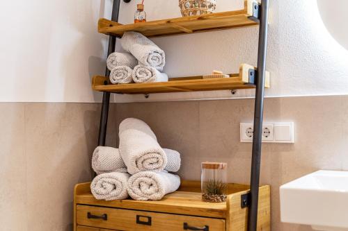 a pile of towels on a wooden shelf in a bathroom at Videre Lodge Gantkofel in Gargazzone