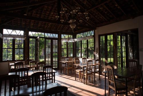 a dining room with tables and chairs and windows at Pousada da Bia in Tiradentes