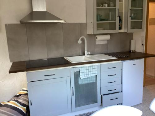 a kitchen with white cabinets and a sink at Ferienwohung zum Wasserfall in Üxheim