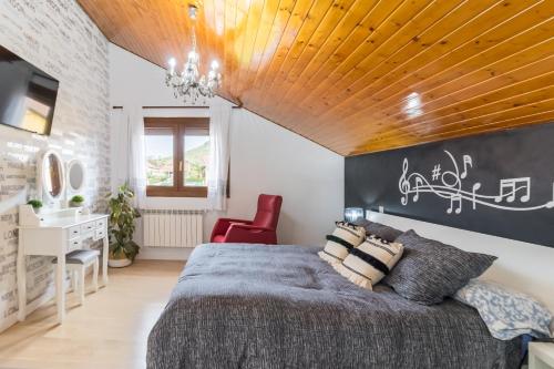 a bedroom with a large bed with a wooden ceiling at Casa Rural Alojamientos Marte in Hinojedo