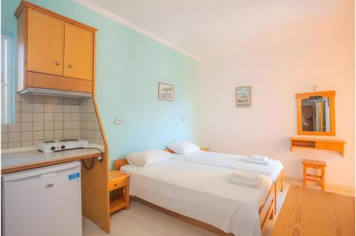 a small room with two beds and a kitchen at Nidri view Apartments in Nydri
