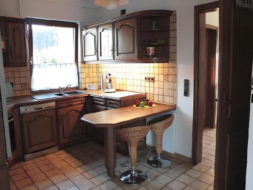 a kitchen with wooden cabinets and a table in it at Ferienhaus Dell in Möhnesee