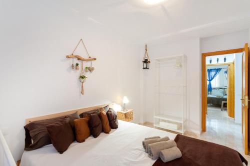 a bedroom with a large white bed with brown pillows at Attaday Home Holidays in Ingenio