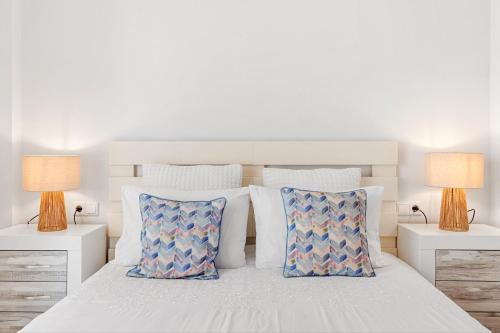 a bedroom with a white bed with pillows and two lamps at Beach Center Only 150 M Luxury in Fuengirola