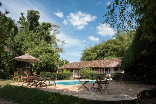 a patio with tables and chairs next to a pool at Pousada da Bia in Tiradentes