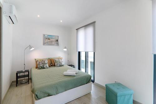 a bedroom with a bed and a large window at Casa Lopes in Fuzeta