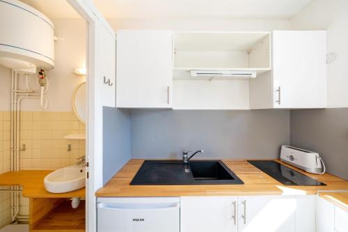 a kitchen with white cabinets and a sink at Les Mimosas - Appartement 08 in Cazaubon
