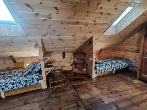 a room with two bunk beds in a log cabin at Gîte La Forge Faverolles in Arcomie