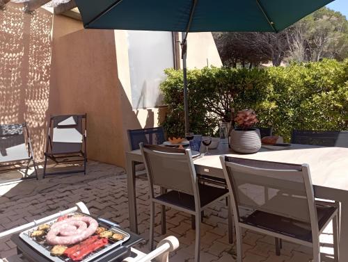 a table with a tray of food and an umbrella at Gîte Capibay Les Herbes de Provence in Six-Fours-les-Plages