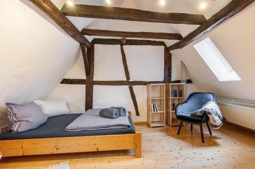 a bedroom with a bed and a chair in a attic at Fachwerkhaus Für Dich in Eberbach