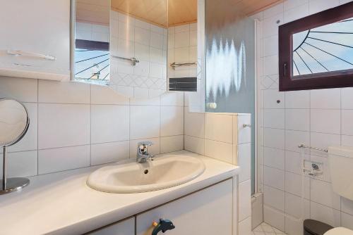 a white bathroom with a sink and a mirror at Frenkhausener Ruhepol in Meschede