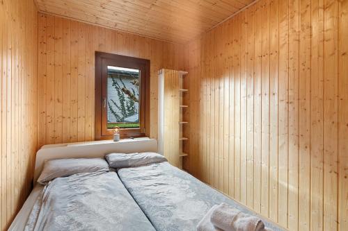 a bedroom with a bed in a wooden wall at Frenkhausener Ruhepol in Meschede