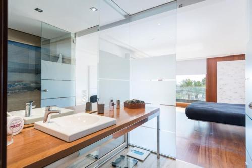 a bathroom with a sink and a glass wall at Marítimo 46 in Alcudia
