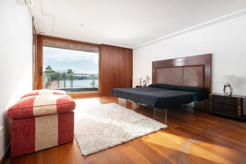 a bedroom with a bed and a chair and a window at Marítimo 46 in Alcudia