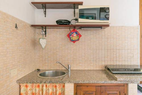 a kitchen with a sink and a microwave at Il Pino - monolocale Lavanda in Cecina