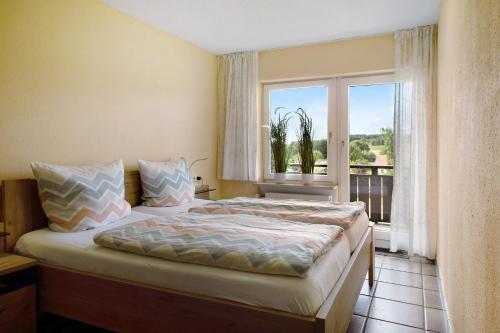 a bedroom with a bed and a large window at Ado Ferienwohnung in Grafenhausen