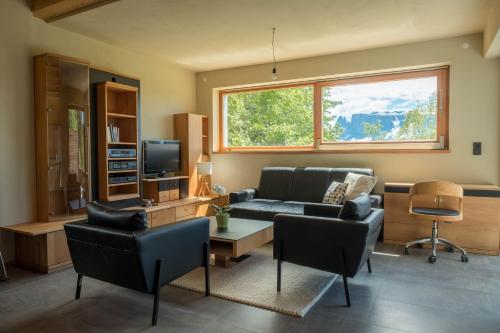 a living room with a couch and a tv at Haus Lichtenstern in Soprabolzano