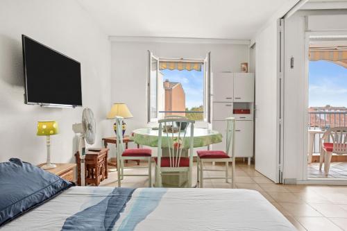 a bedroom with a bed and a dining room with a table at Appartement à deux pas de la mer in Fréjus