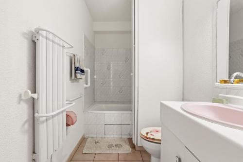 a white bathroom with a sink and a toilet at Appartement à deux pas de la mer in Fréjus